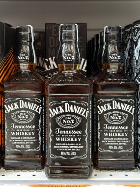 Jack Daniel 'ın 7 numaralı Tennessee viski şişeleri bir süpermarket rafında düzgünce düzenlenmiş. Udine, İtalya. 19 Haziran 2025