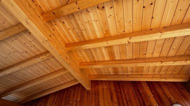 Açığa çıkarılmış ahşap kirişleri, kırsal ya da modern inşaat tarzının mimari ayrıntıları olan katranlı tavanın iç görünümü.