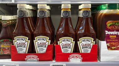 Heinz klasik barbekü ketçap şişeleri süpermarket rafında. Udine, İtalya. 19 Haziran 2025