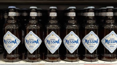 Tuz kristalli Messina bira şişeleri, bir mağaza rafında güzelce yerleştirilmiş. Udine, İtalya. 19 Haziran 2025