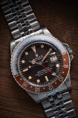 Antika Rolex GMT Ustası 1960 'lardan kalma otomatik kol saati, referans 1675, ahşap bir yüzeyde oturuyor. Milan mı? İtalya 14 Nisan 2025