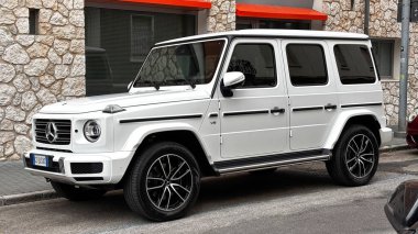 Mercedes-Benz G 500 V8 lüks SUV bir şehir merkezinde park halinde. Güç, zarafet ve modern tasarımı birleştiren ikonik bir off-road aracı. Udine, İtalya. 21 Haziran 2025