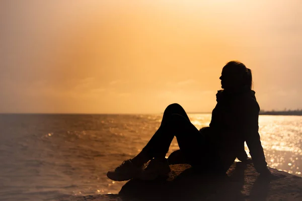 Silhouette Eines Mädchens Das Bei Sonnenuntergang Auf Einem Stein Meer — Stockfoto