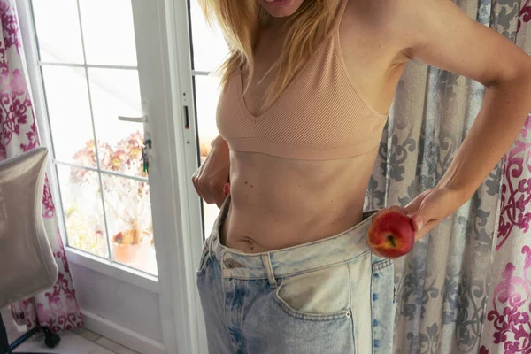 Una Chica Deportiva Para Pantalones Vaqueros Grandes Tiene Una Manzana — Foto de Stock