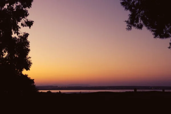 日落时的美丽的自然照片 美丽的落日映衬在树木和湖面上 有一处地方可以作题词 高质量的照片 — 图库照片
