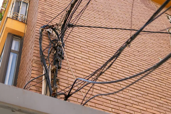 many electrical wires on the wall of a multi-story building. High quality photo