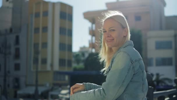 Улыбающаяся Блондинка Джинсовой Куртке Смотрит Камеру Улице Чувствуя Себя Счастливой — стоковое видео