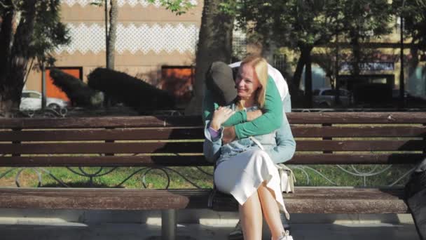 Ein Mädchen Sitzt Auf Einer Bank Park Ein Kerl Umarmt — Stockvideo
