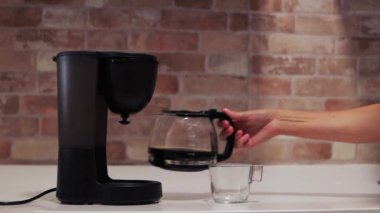 kadın elleri kahve makinesinden kahve doldurur ya da kahve makinesinden sabah erkenden mutfakta bir fincana, konsept olarak. Yüksek kalite 4k görüntü
