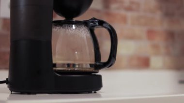 Kahve makinesi masaya yakın, kahve makinesi mutfakta kahve yapıyor, kapat. Yüksek kalite 4k görüntü