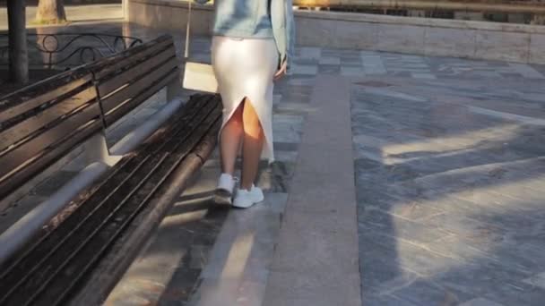 Девушка Белом Платье Джинсовой Куртке Сумкой Плече Проходит Через Парк — стоковое видео