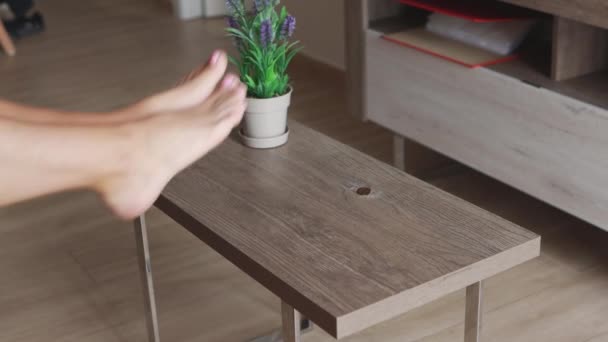 Uma Menina Coloca Suas Pernas Delgadas Uma Mesa Café Casa — Vídeo de Stock