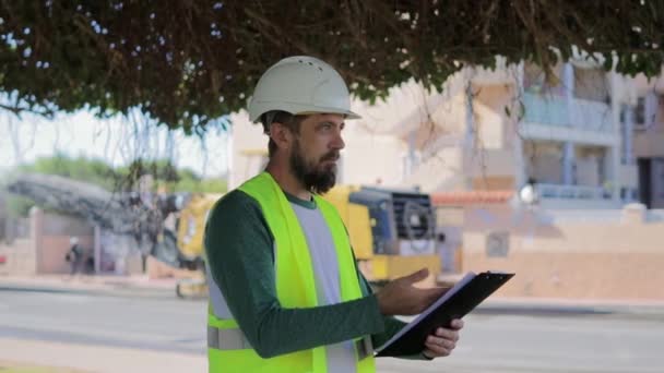 Trabajador Casco Con Una Carpeta Documentos Cerca Carretera Que Está — Vídeo de stock