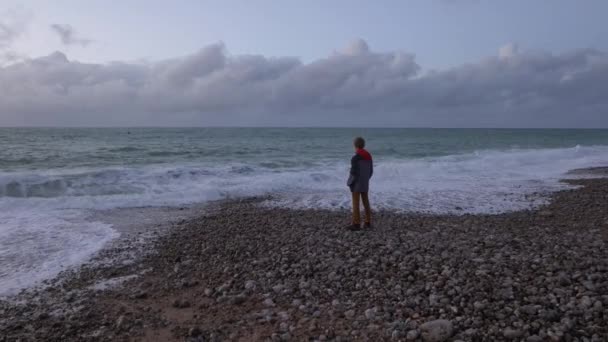 Sırtı Kameraya Dönük Bir Şekilde Okyanus Kıyısında Çakıl Taşının Üzerinde — Stok video