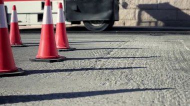 Yol bakımı koni statik yakın çekim. Caddedeki yol çalışması tabelaları. Yol üzerindeki yol çalışması tabelası. Yoldaki tamirat işi. İşçiler yeni asfalt döşedi. İş konisi paraziti. Yüksek kaliteli FullHD görüntüler