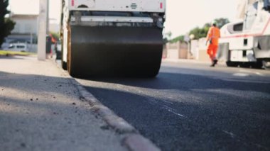 Yol silindirleri yeni bir yolda gidiyor. Yol tamiri. Ağır makineler. Yol inşaatında asfalt kaldırım taşı makinesi. Residential Caddesi 'ndeki Paving Yolu. Asfalt döşeme. Yüksek kaliteli FullHD görüntüler