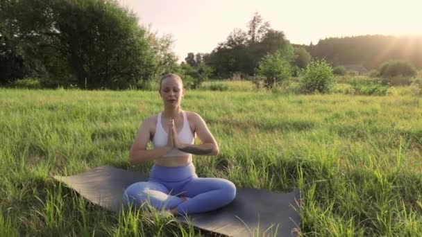 Молодая Женщина Занимается Йогой Летнем Закате Фоне Зеленой Травы Упражнения — стоковое видео