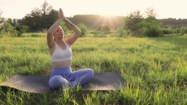 Kadın meditasyonu, zen yoga meditasyonu. Yogi kızı nilüfer çiçeği pozunda oturuyor, sağlıklı yaşam tarzı, meditasyon konsepti. Yüksek kaliteli FullHD görüntüler
