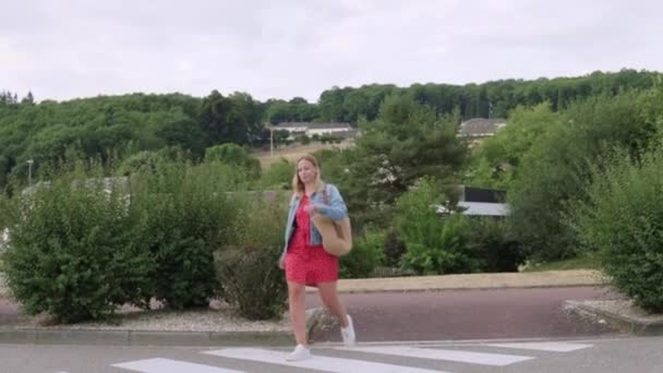 Kırmızı Elbiseli Bir Kız Kot Ceketli Omuzunda Bir Çantayla Yaya — Stok video