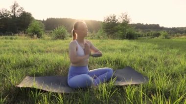 Kadın meditasyonu, zen yoga meditasyonu. Yogi kızı nilüfer çiçeği pozunda oturuyor, sağlıklı yaşam tarzı, meditasyon konsepti. Yüksek kaliteli FullHD görüntüler