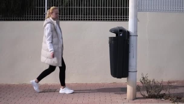 若い女性がゴミ箱の隣にゴミを投げる 街の通りを歩いている間に 環境汚染の概念 高品質のフルHd映像 — ストック動画