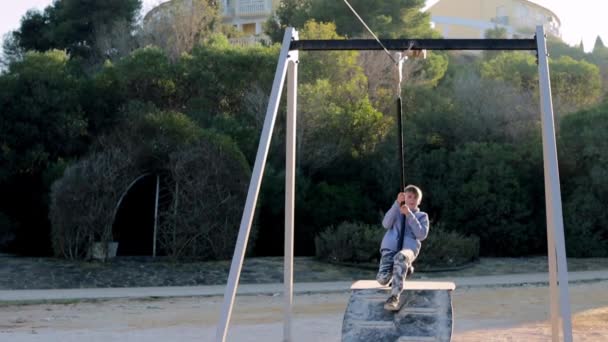 子供のための公園のバンジーに乗って公正な外観の幸せな少年 ケアフリーで幸せな子供時代の概念 高品質のフルHd映像 — ストック動画