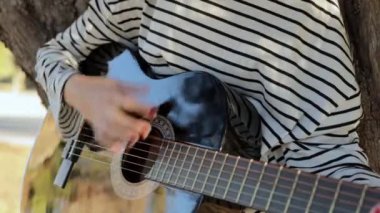 Parkta gitar çalan ergen kızlar. Yeşil doğa parkında solo gitar çalan bir kız. Yüksek kalite 4k görüntü