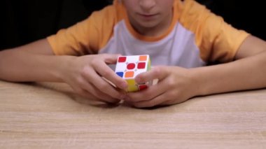  Rubiks küpünün nasıl monte edileceğini öğrenen bir çocuk. Rubiks Küpü 3 boyutlu bir bulmaca Yüksek kalite 4k görüntü