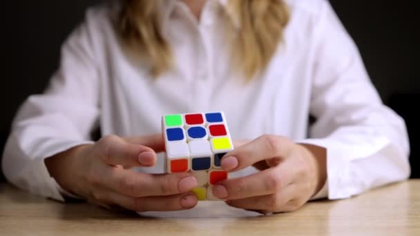Dívka Sedí Stolu Bílé Košili Snaží Vyřešit Rubiksovu Kostku Vysoce — Stock video