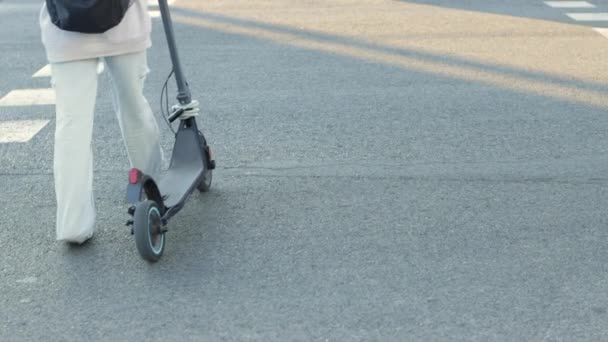 Visão Traseira Uma Jovem Com Uma Scooter Cruzando Estrada Uma — Vídeo de Stock