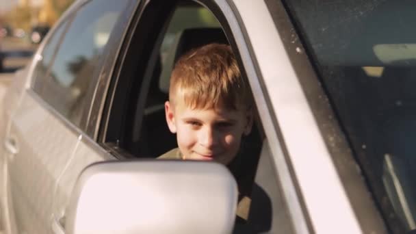Gelukkige Tiener Jongen Zit Passagiersstoel Een Auto Vrolijk Grimmig Naar — Stockvideo
