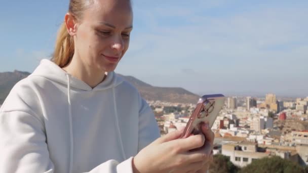 Menina Turística Feliz Sentado Admirando Vista Cidade Cima Segurando Telefone — Vídeo de Stock