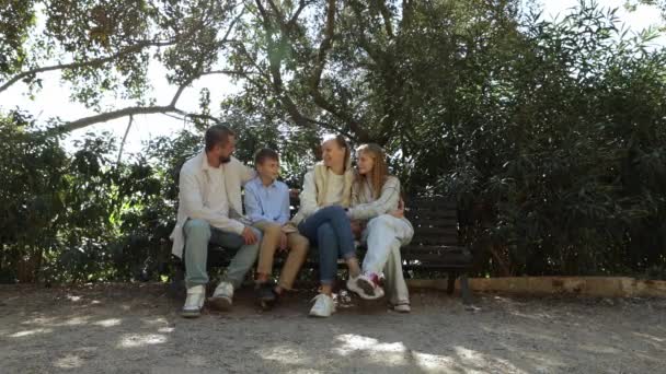 快乐的家庭妈妈爸爸和两个孩子坐在长椅上聊天 快乐的家庭观念 高质量的4K镜头 — 图库视频影像