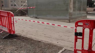 Şehir caddesi boyunca kırmızı ve beyaz şeritli koruyucu bir şerit gerildi. Sokak tamiri. Yüksek kalite 4k görüntü