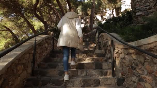 軽いジャケットを着た観光ガールが 市立公園の階段を登ります 高品質の4K映像 — ストック動画