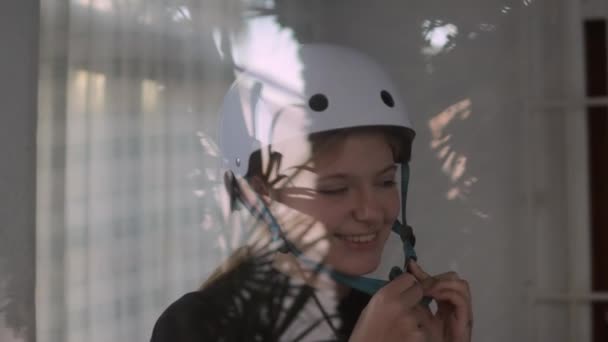 Μια Όμορφη Ξανθιά Βάζει Ένα Λευκό Κράνος Ποδηλάτου Στο Κεφάλι — Αρχείο Βίντεο