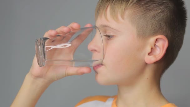 Netter Junge Trinkt Sauberes Wasser Aus Einem Glas Auf Grauem — Stockvideo