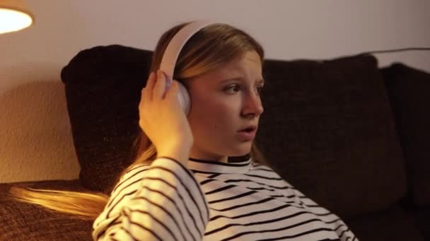 Uma Adolescente Vestida Com Uma Camisola Listrada Senta Confortavelmente Sofá — Vídeo de Stock