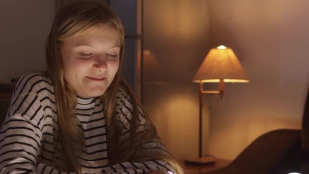 鼻のピアスが付いている10代の少女は本に吸収されるソファーに快適に座ります 若々しい好奇心と知的探求 読書の喜び 個人的な成長 そして静けさの概念 — ストック動画