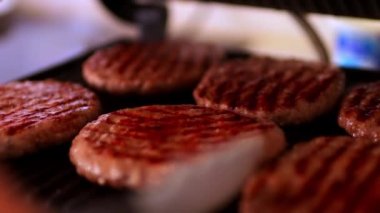 Hamburger ızgarası. Hamburger hazır, spatulası olan şef de burgeri ızgaradan çıkardı. Et suyu ve yağın geri kalanı ızgarada kalacak. Yüksek kaliteli FullHD görüntüler