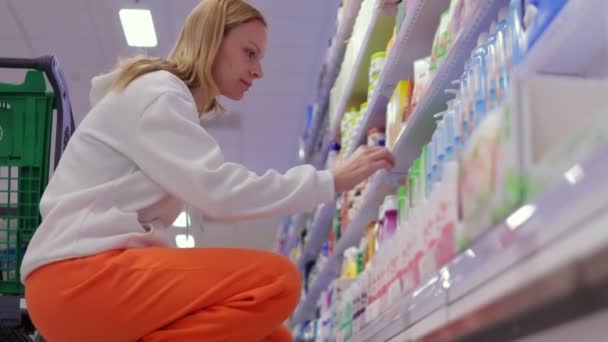 Kozmetik Bölümünde Duran Bir Kadın Kozmetik Ürününün Bileşimini Dikkatle Okur — Stok video