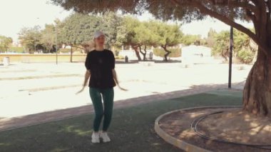 Bir fitness kızı bacakları için egzersiz yapar, kalça ve diz kaslarını çalıştırır ve temiz havada dinlenir. 30 'lu yaşlarındaki narin atletik kadın dışarıda egzersiz yapıyor. Doğa sporu. Yüksek