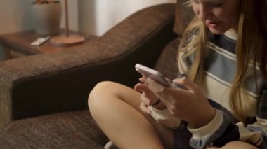 Sosyal medyayı taramak için cep telefonu kullanan güzel bir kızın videosunu kapat. İnternetten alışveriş yapan gülümseyen genç bir kız. İnternetten mal sipariş eden, video izleyen. Yüksek kalite FullHD