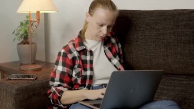 Kanepede oturan kadın, bilgisayarın başında özenle uzaktan kumandalı görevleri çözmeye çalışıyor. Görevlerini hassasiyet ve konsantrasyonla tamamlıyor, çevresine dikkat etmiyor. Yüksek