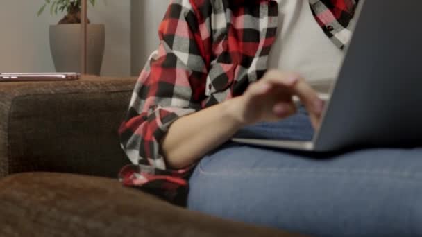 Açık Tenli Bir Kız Kanepede Oturuyor Bilgisayarın Başında Özenle Çalışıyor — Stok video