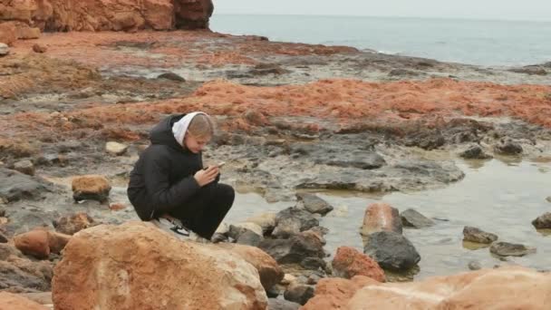 Ένα Ελκυστικό Νεαρό Κορίτσι Στέκεται Ένα Βράχο Στην Παραλία Και — Αρχείο Βίντεο