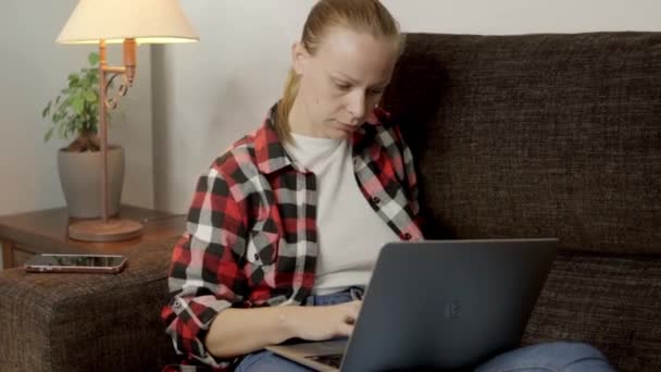 Sentada Sofá Mulher Trabalha Atentamente Computador Resolvendo Diligentemente Tarefas Remotas — Vídeo de Stock