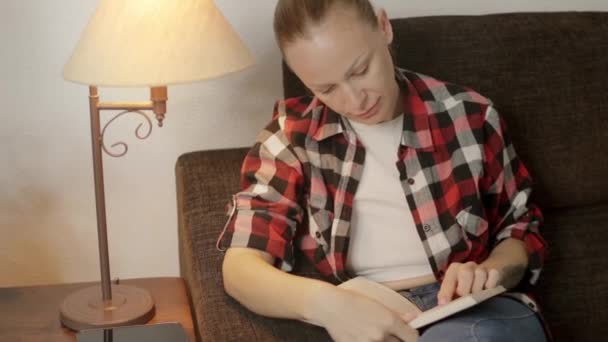 Oturma Odasının Sıcak Atmosferinde Açık Tenli Bir Kız Kitap Okumaya — Stok video