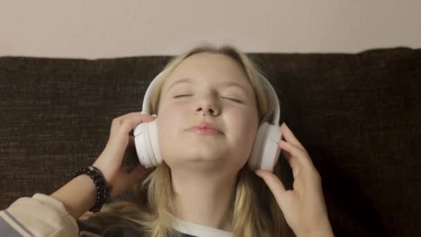 肖像画描绘了一个带着鼻孔的Gen Z女孩 沉浸在耳机里播放的音乐节奏中 她闭上眼睛 嘴角挂着微笑 跟着歌声唱着 — 图库视频影像