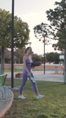 Genç bayan parkta esneme egzersizi yapıyor..